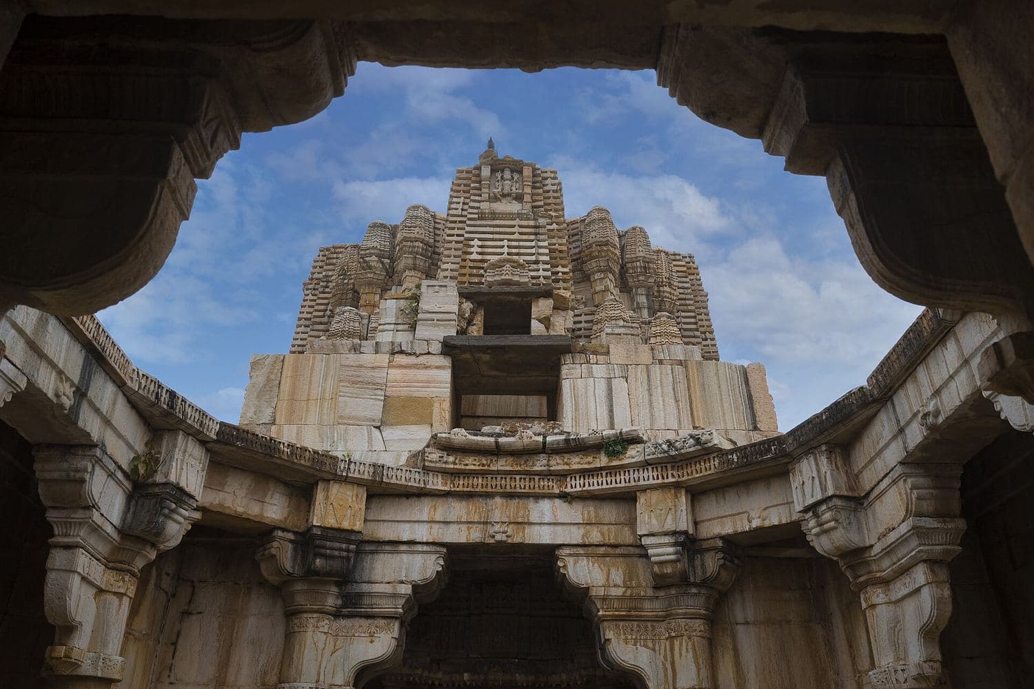 A carved stone temple framed by an archway inside Chittorgarh Fort